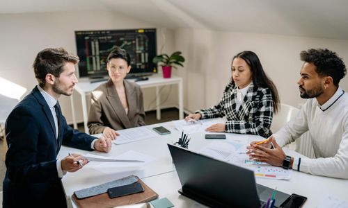 Business team analyzing financial model on laptop screen